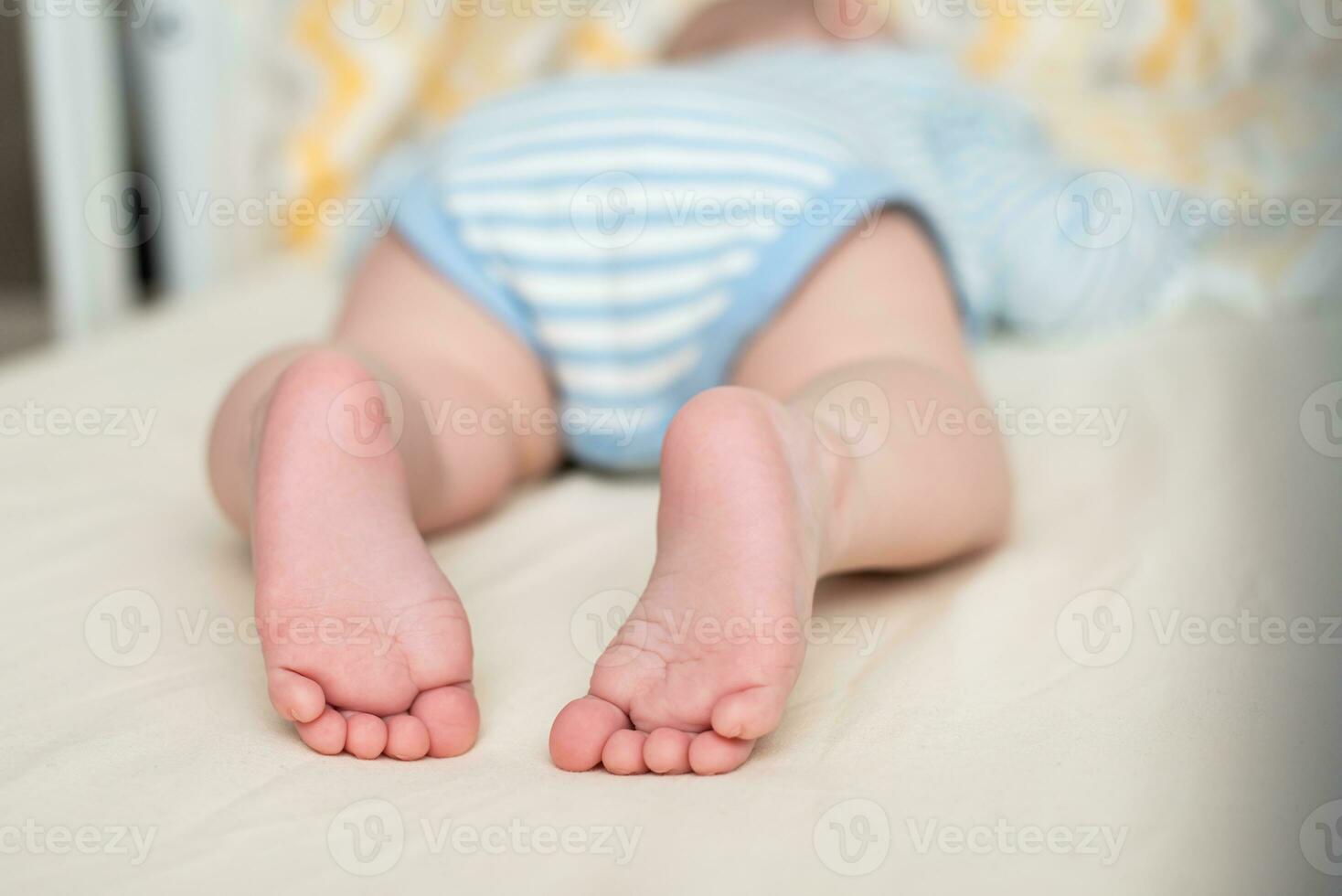 piernas de un dormido bebé en el cuna. niño pie. foto