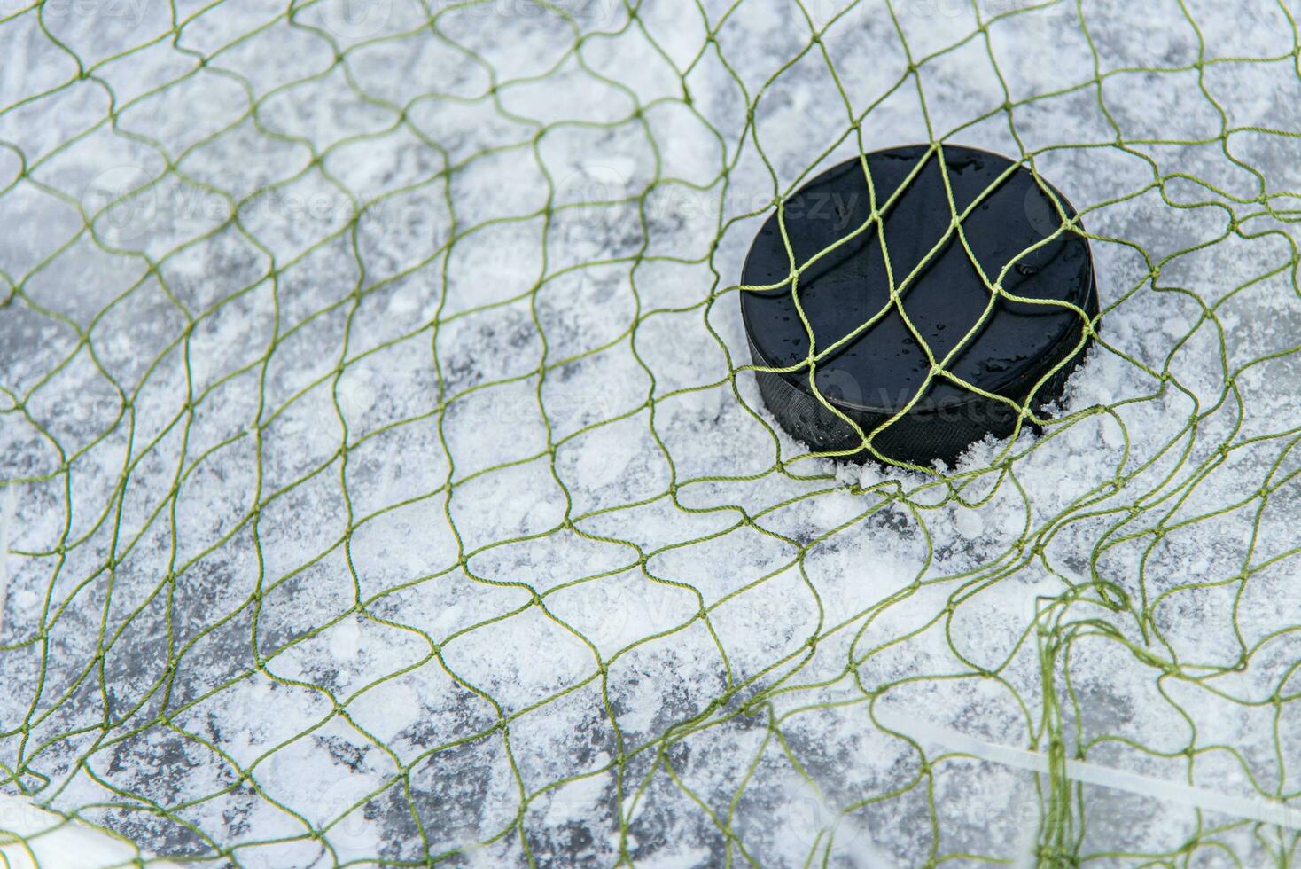 hockey puck in the goal net close-up photo