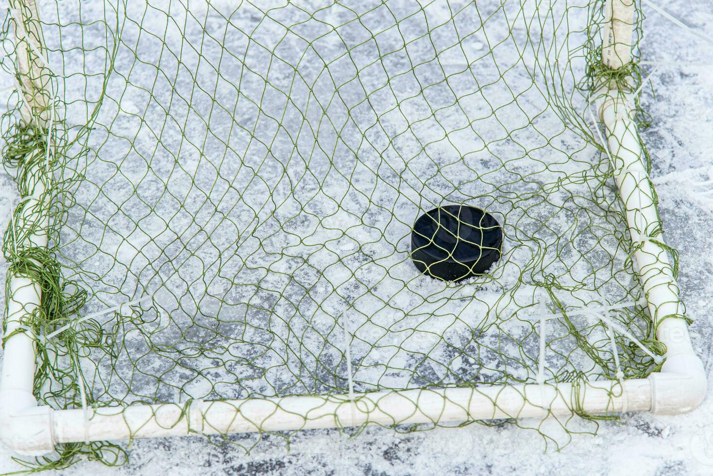 hockey puck in the goal net close-up photo