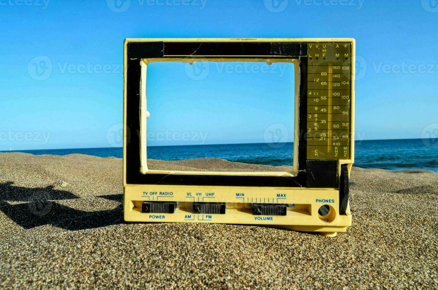 a small old television on a beach photo