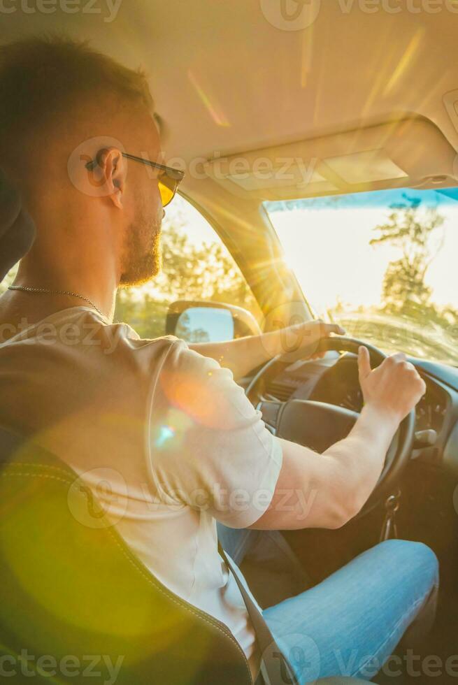 un hombre conducción un coche en un soleado día foto
