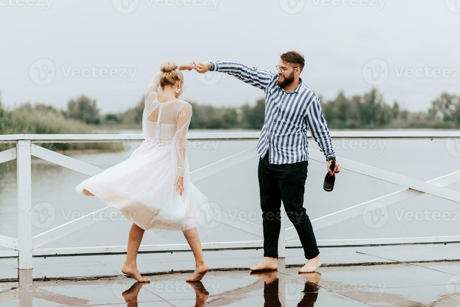 hermosa sólo casado danza descalzo y tener divertido en el muelle por el agua. foto