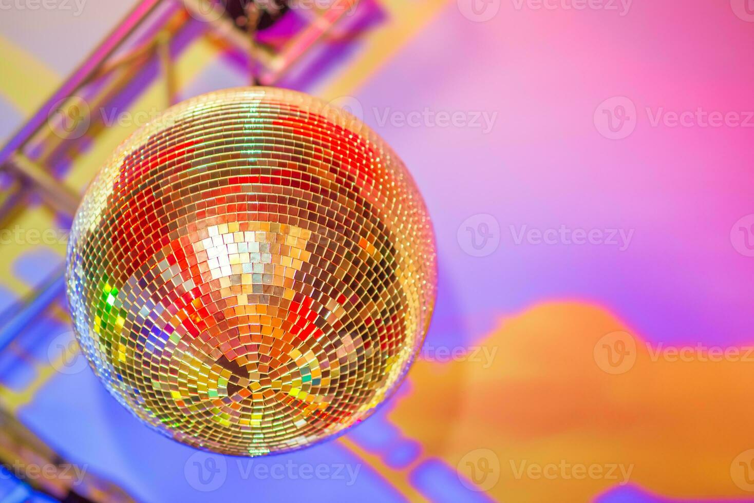 Big disco ball on a colored background in a nightclub photo