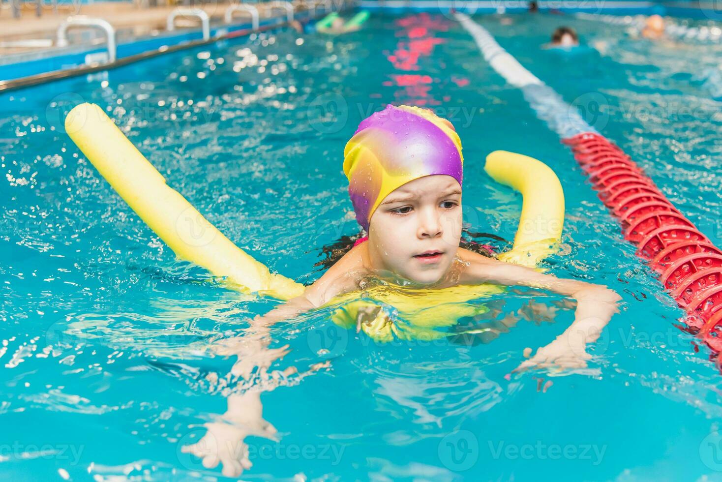 Small child swim in an indoor pool. photo