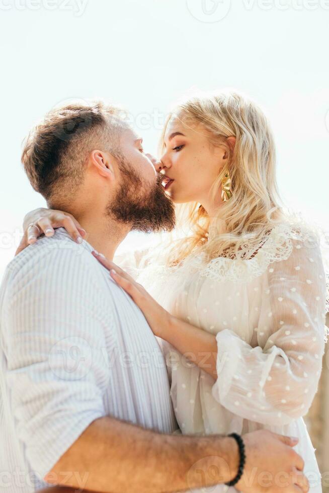 Loving and happy couple kissing outdoors in summer photo