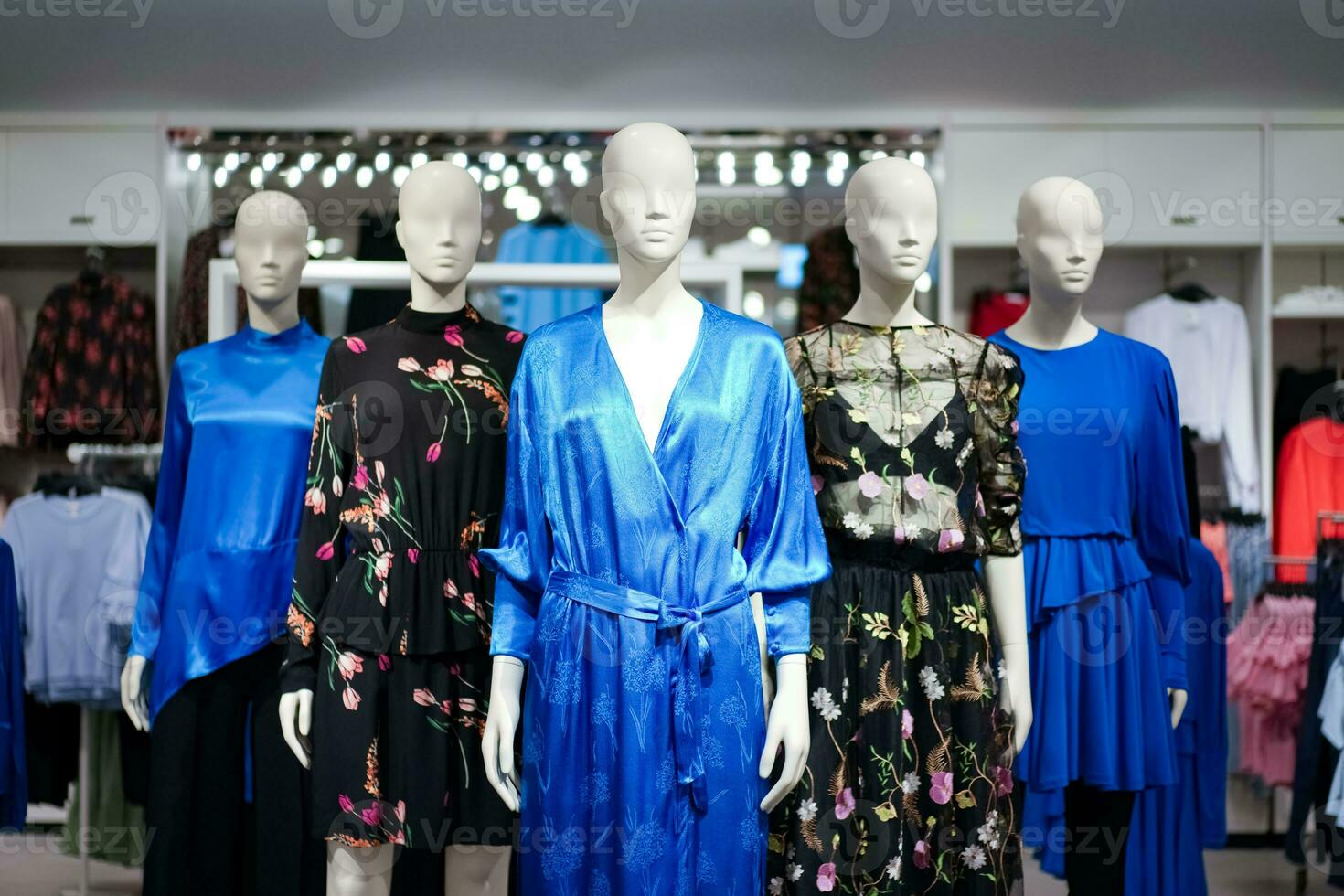 Female mannequins are dressed in casual clothes with a red-orange theme in fashion shop at the department store. photo