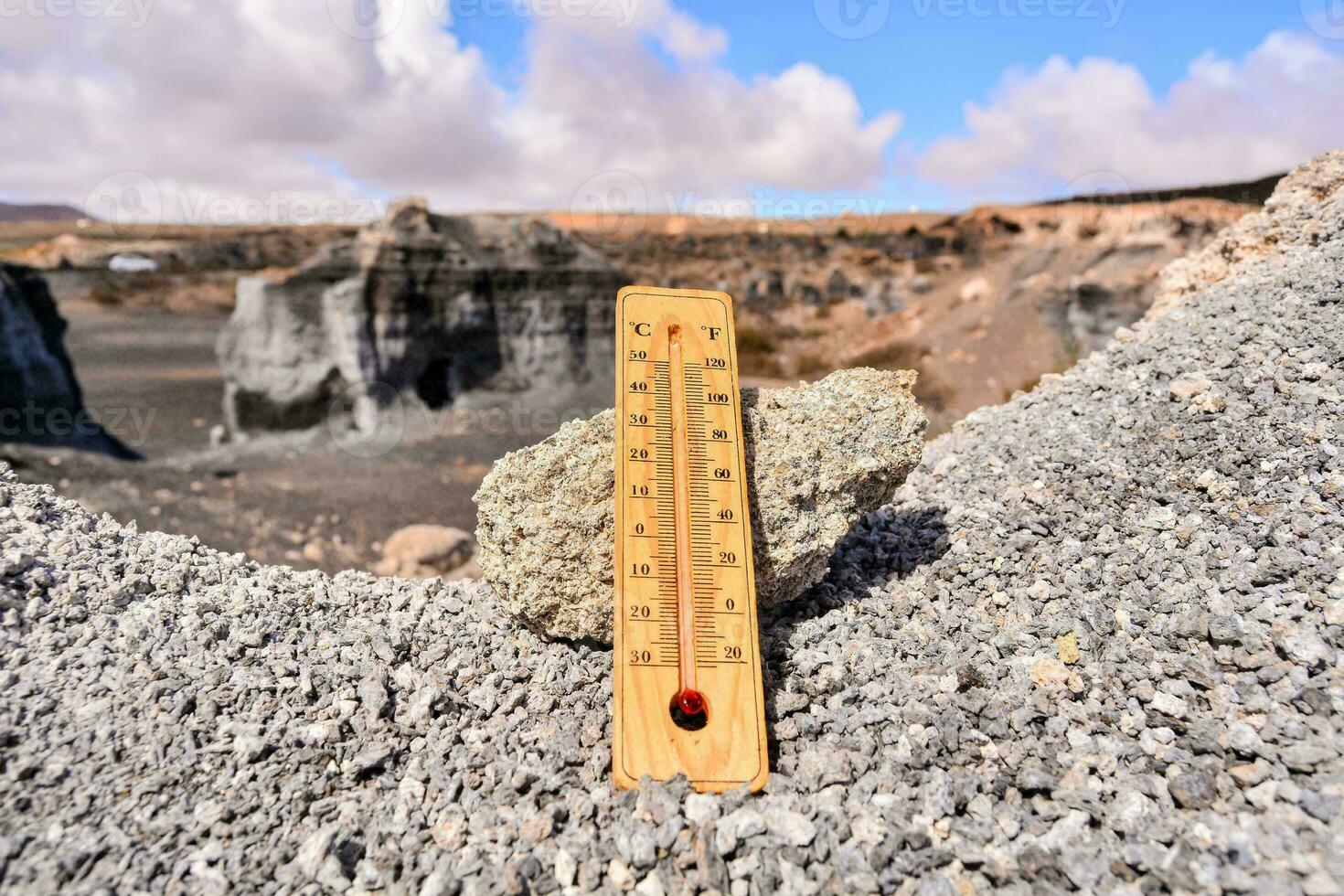 a thermometer in the middle of a rocky landscape photo