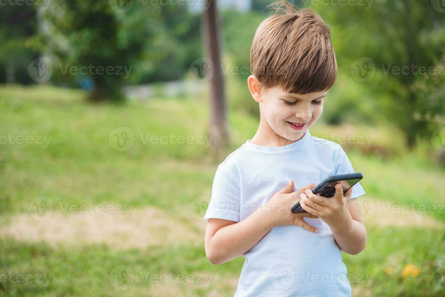the child speaks on the phone in nature photo