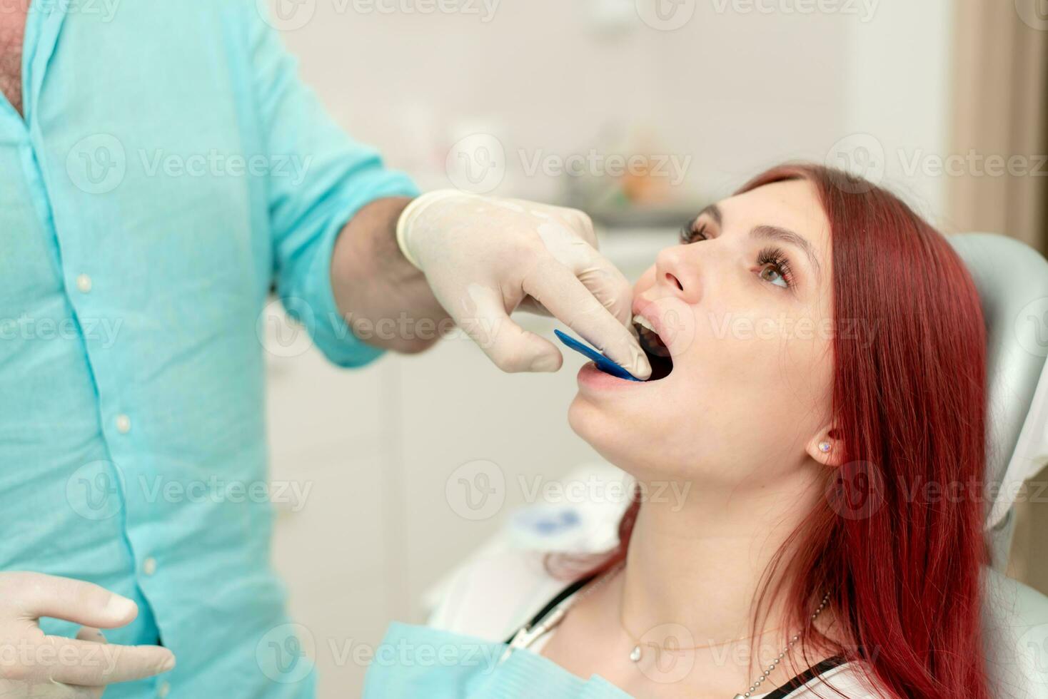 el ortodoncista muestra el paciente un impresión bandeja en cuales el silicona impresión material será ser metido a obtener el forma de su dientes foto