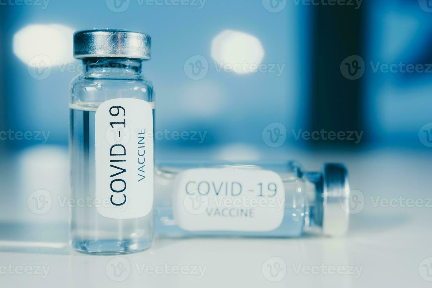 Vaccine against coronavirus COVID-19 in an ampoule on a blue background close-up. photo