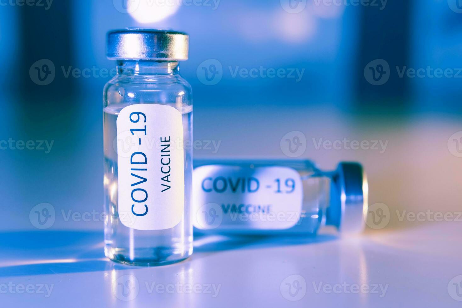 Vaccination against coronavirus COVID - 19. Vial on a blue background close-up. Concept. photo