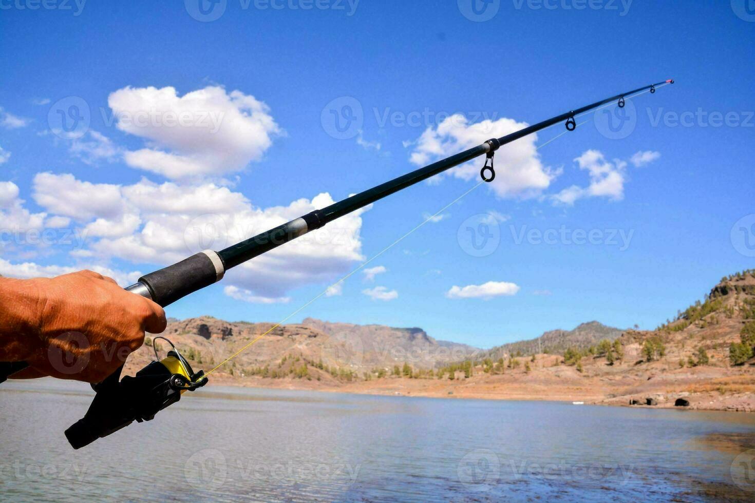 un persona participación un pescar varilla en el agua foto