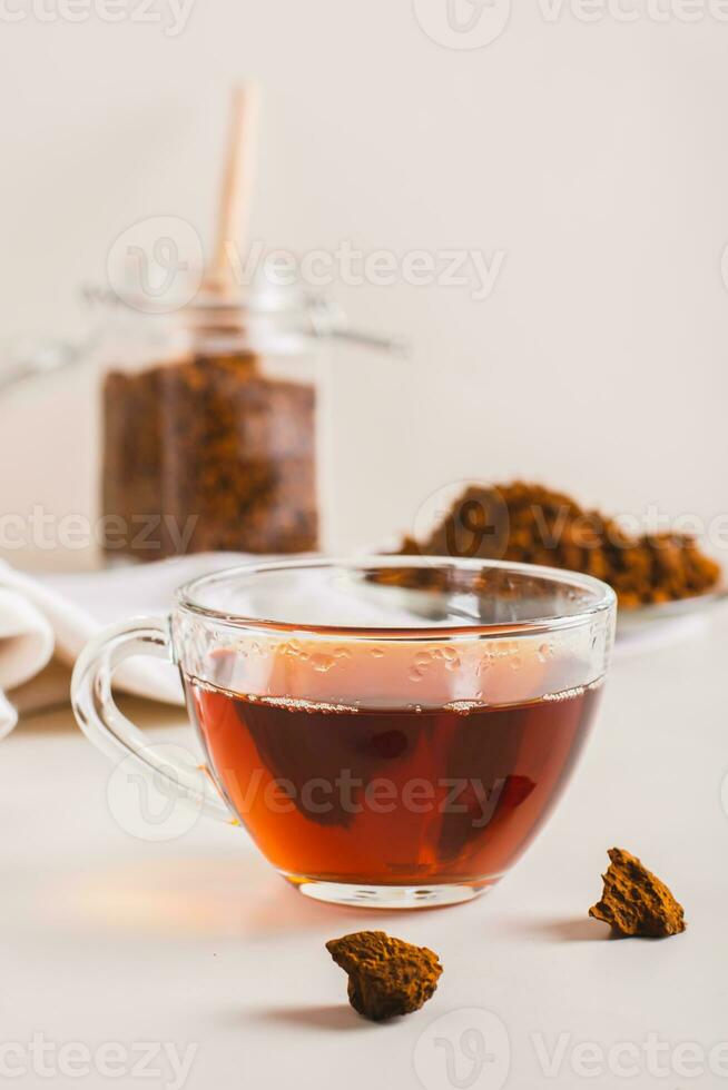 Chaga therapeutic tea from birch mushroom in a cup on the table vertical view photo
