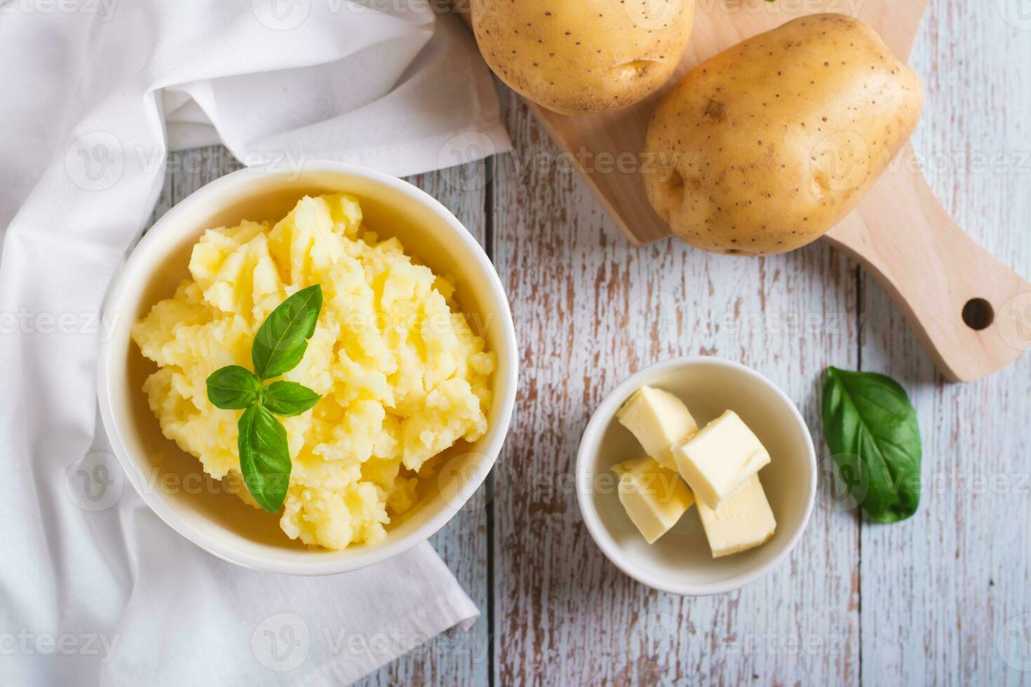 Fresco machacado patatas y albahaca hojas en un cuenco en el mesa parte superior ver foto