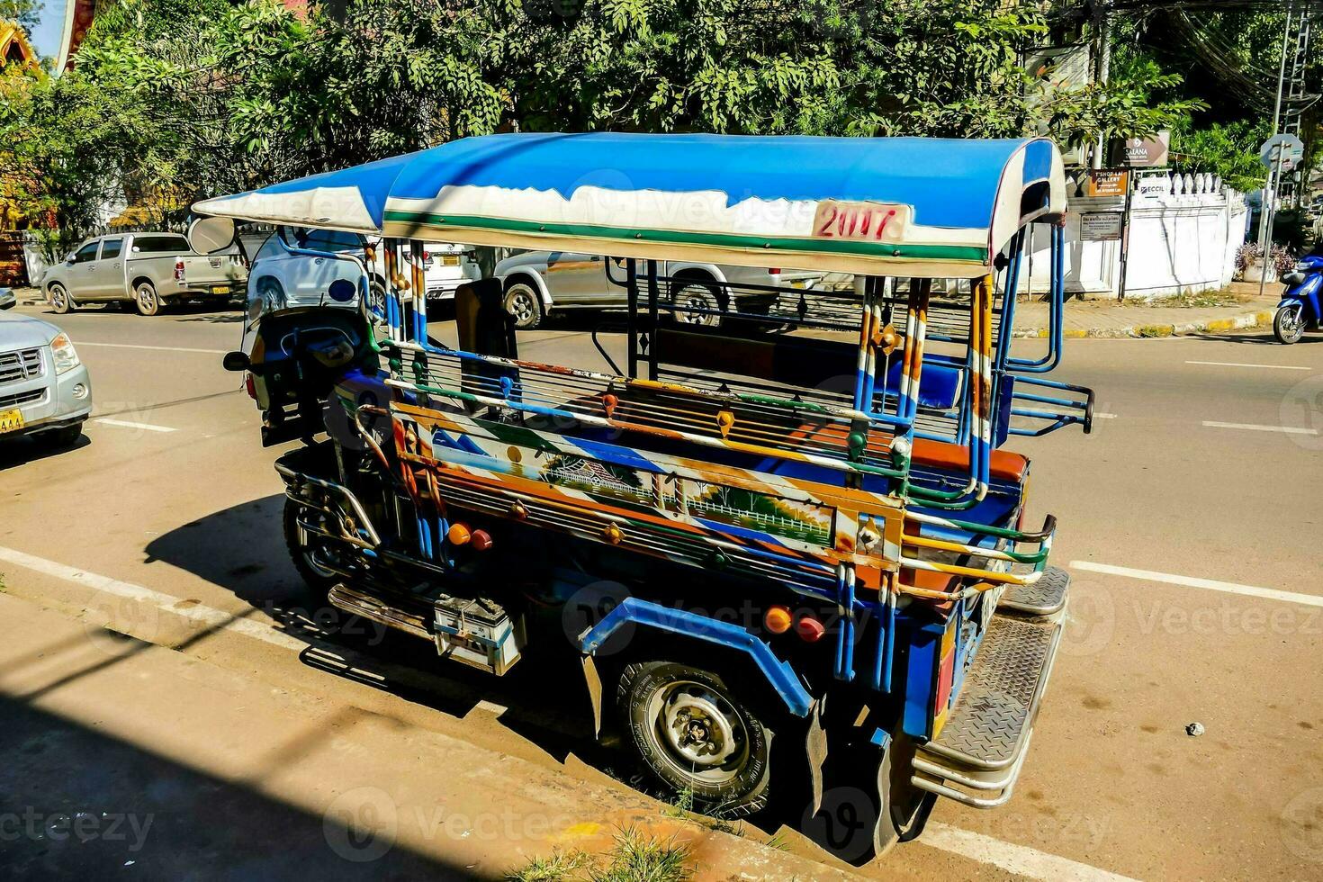a tuk tuk is parked on the side of the road photo