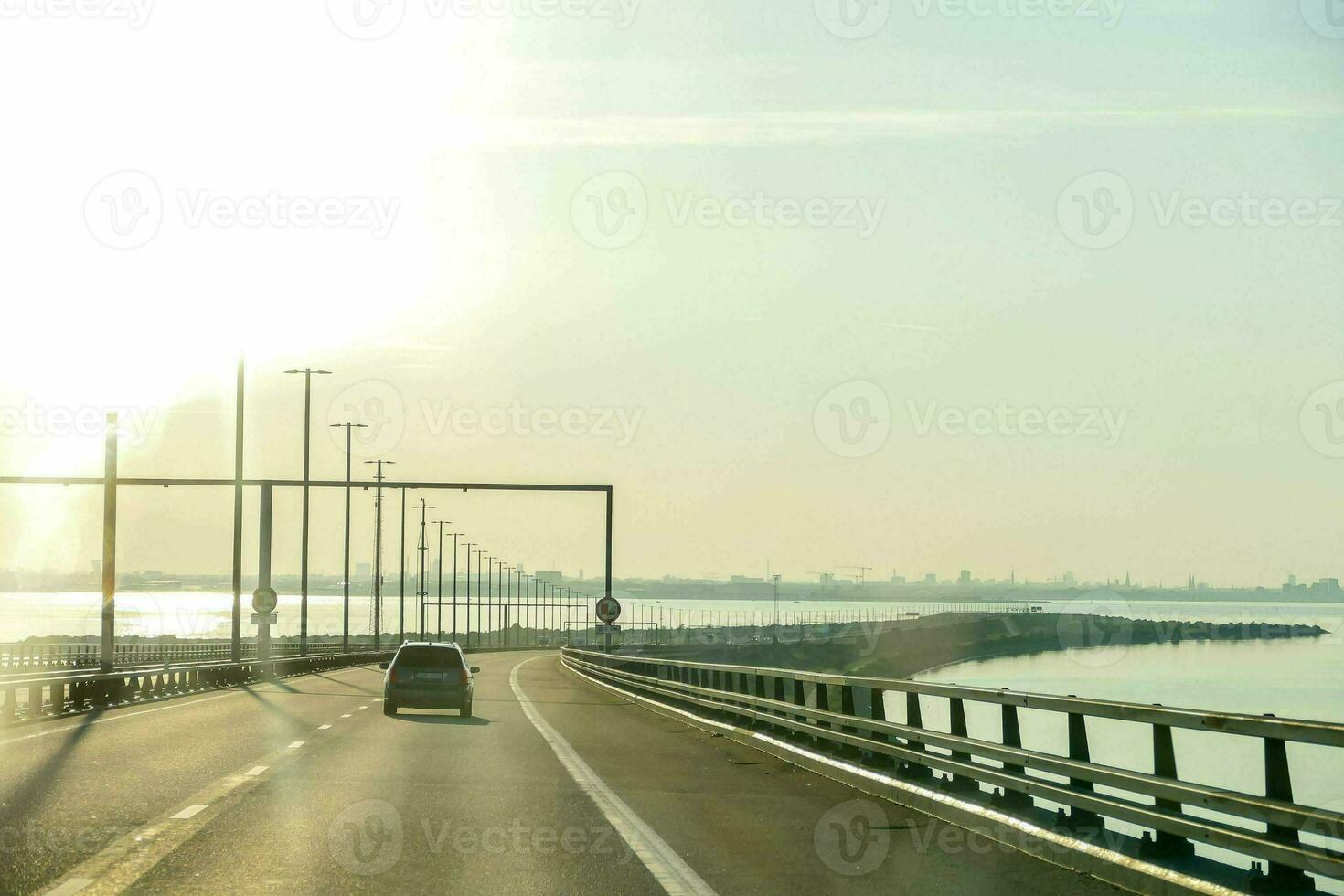 a car driving on a bridge over water photo