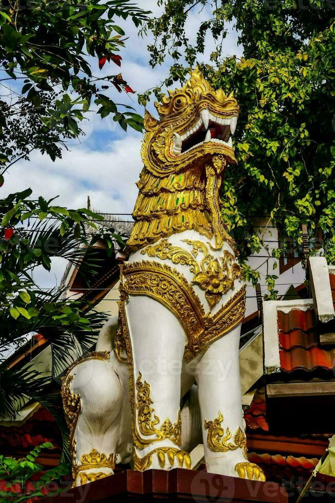 a golden lion statue on top of a building photo
