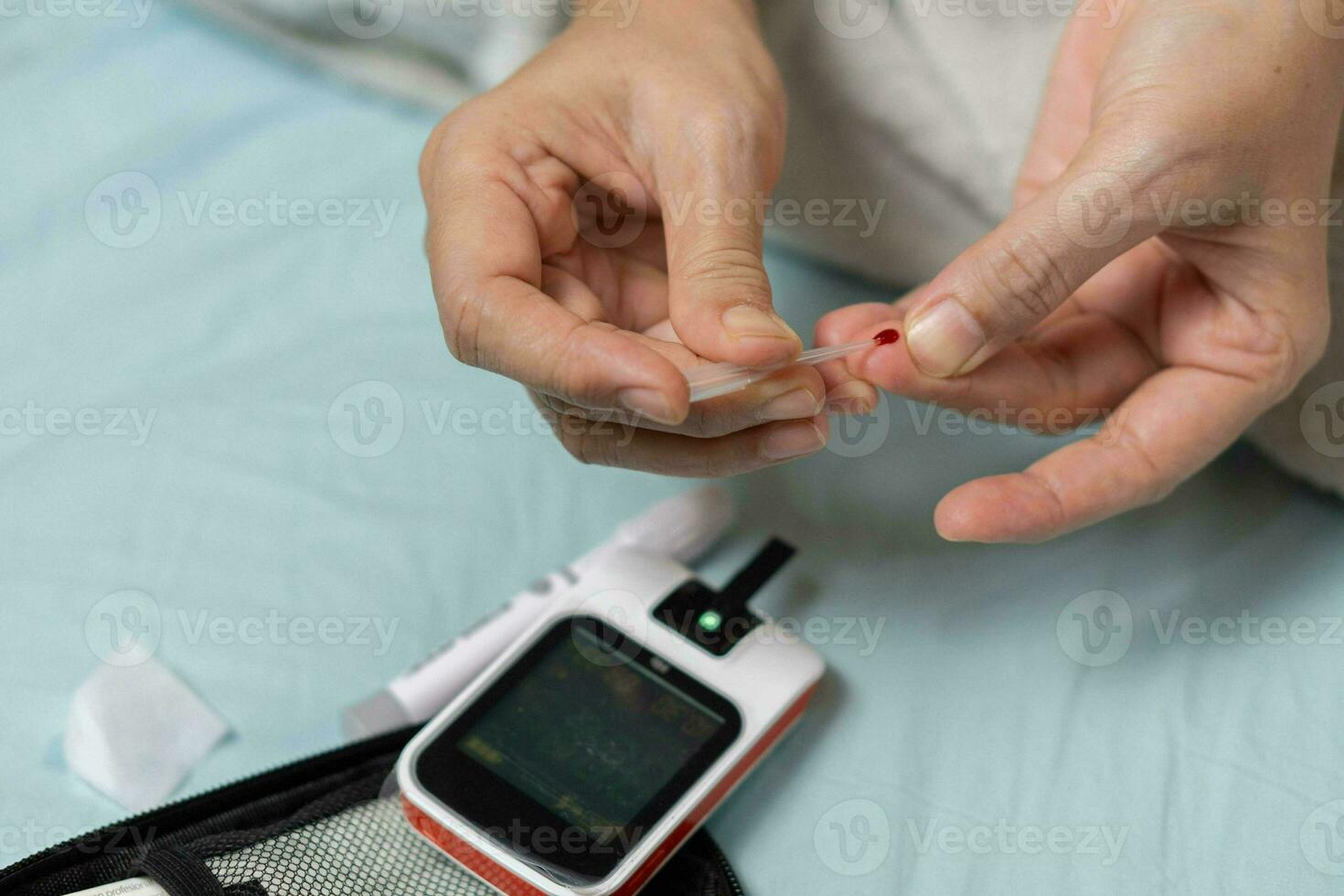 A woman's hand checking her blood sugar level with a glucometer by herself at her home. SHOTLISThealth photo