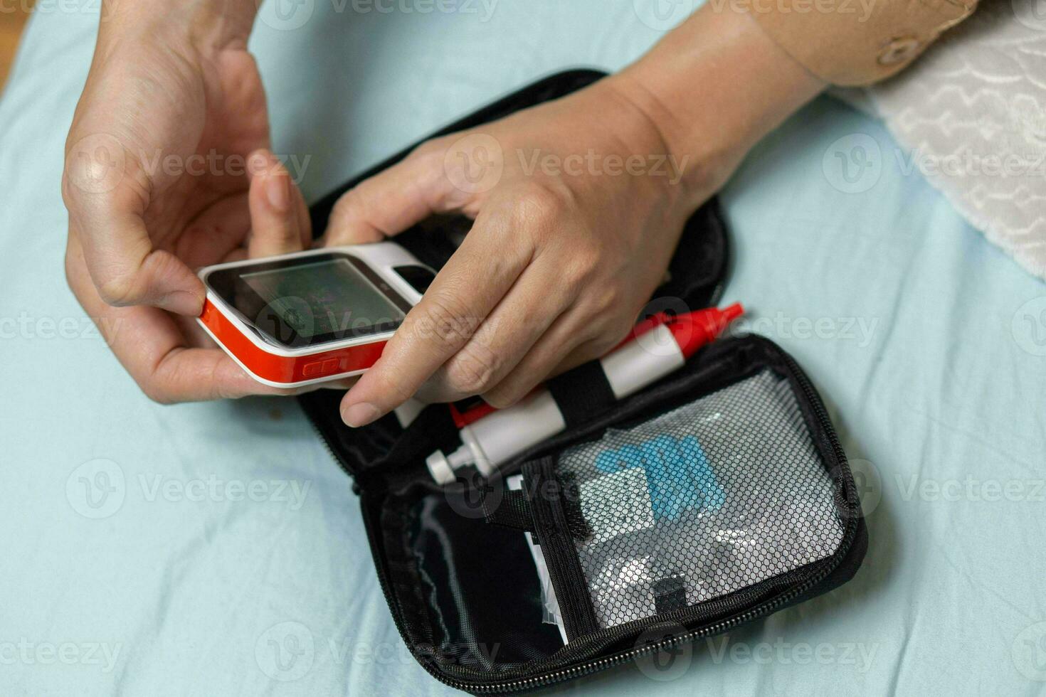 A woman's hand checking her blood sugar level with a glucometer by herself at her home. SHOTLISThealth photo