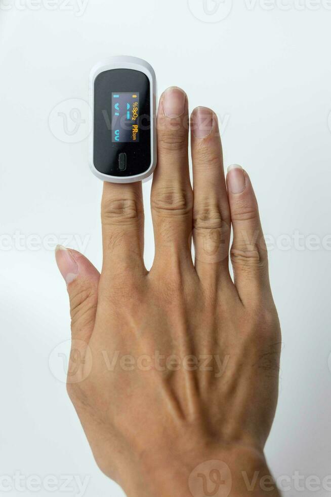 Close up of human finger while using Pulse Oximetry isolated on white background. photo