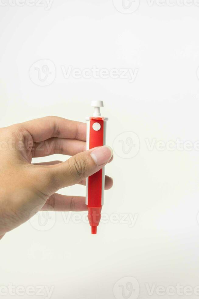 hembra mano con lanceta bolígrafo en blanco antecedentes. diabetes concepto foto