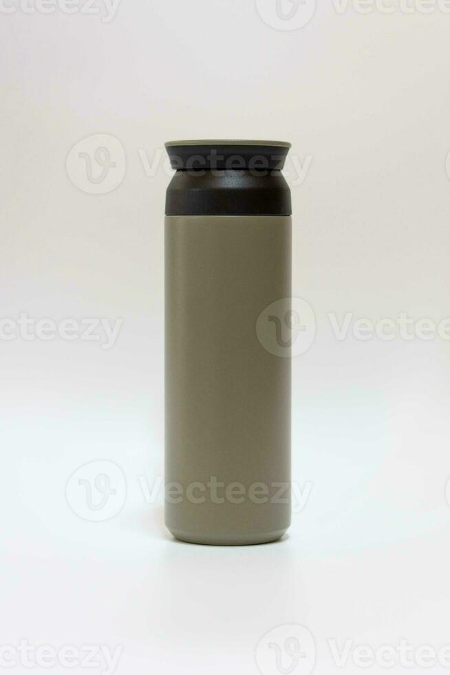 Blank green trendy closed travel flask. Empty traveler bottle and drink container template isolated on white background. Thermo mug for hot or cold beverage. For mockup and branding. photo