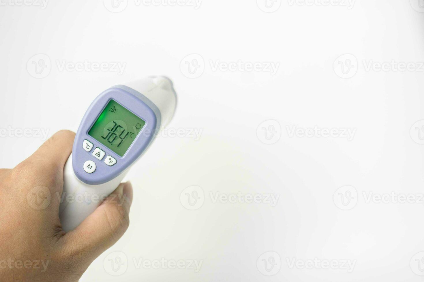 hand holding digital infrared thermometer isolated on white background. with copy space photo