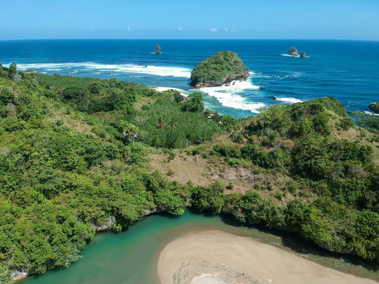 Ungapan Beach is in East Java, Indonesia, with shadow rays that reflect into the forests and blue sea water photo