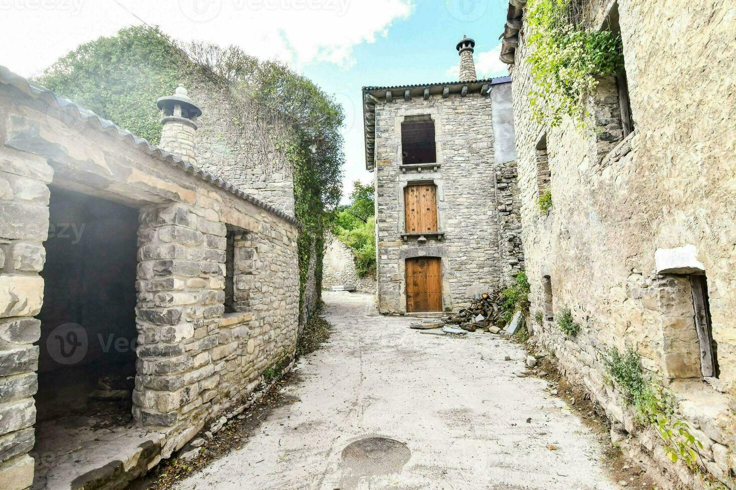 un estrecho callejón con Roca edificios y un puerta foto