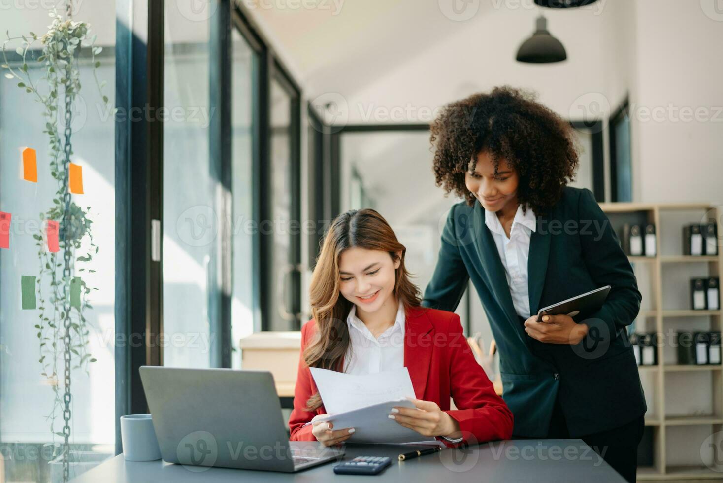 Two business workers talking on the smartphone and using laptop at the office. photo
