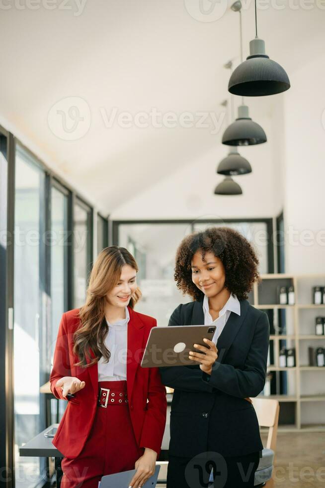 dos negocio trabajadores hablando en el teléfono inteligente y utilizando ordenador portátil a el oficina. foto