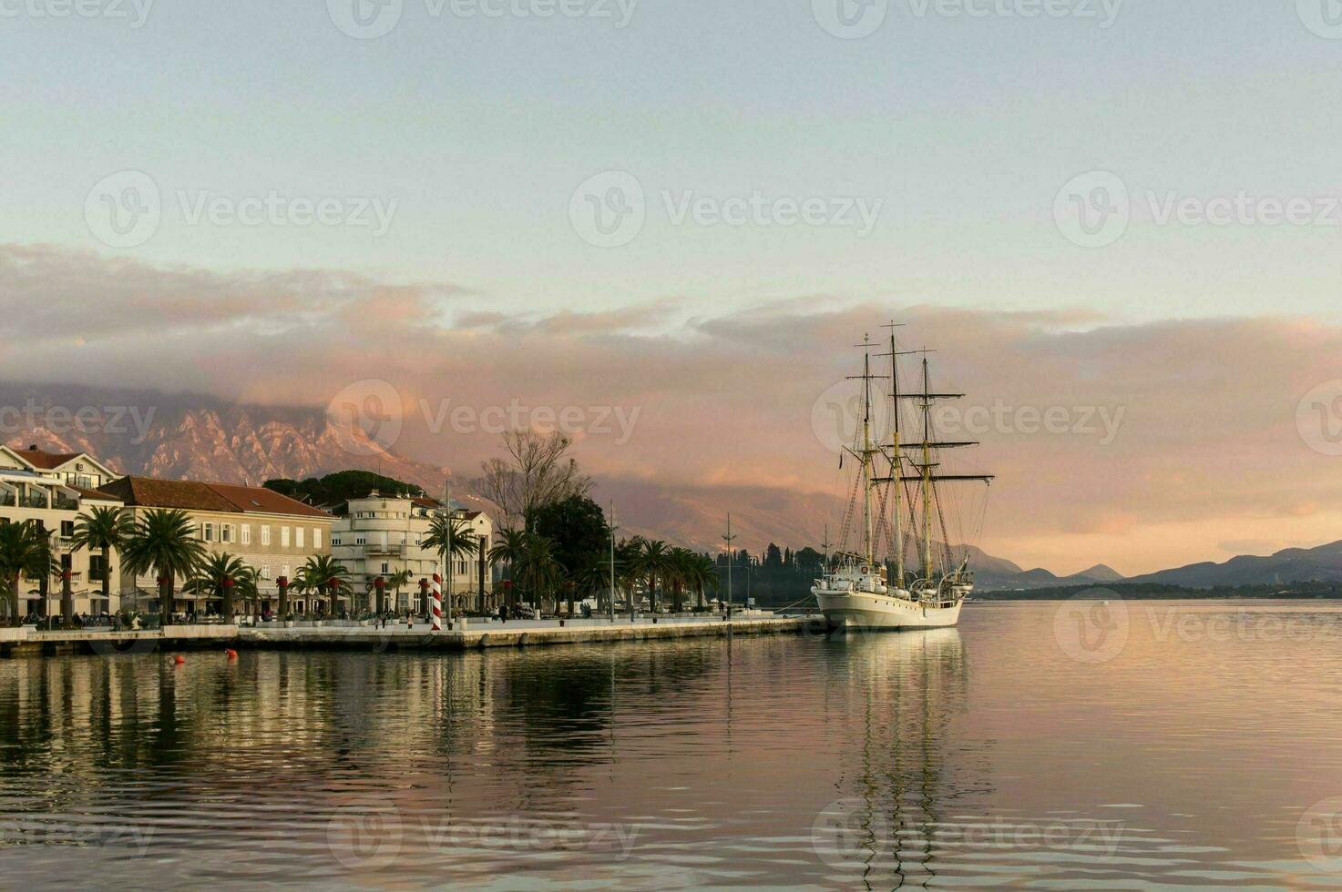 sailing ship in the bay against the backdrop of the mountains photo