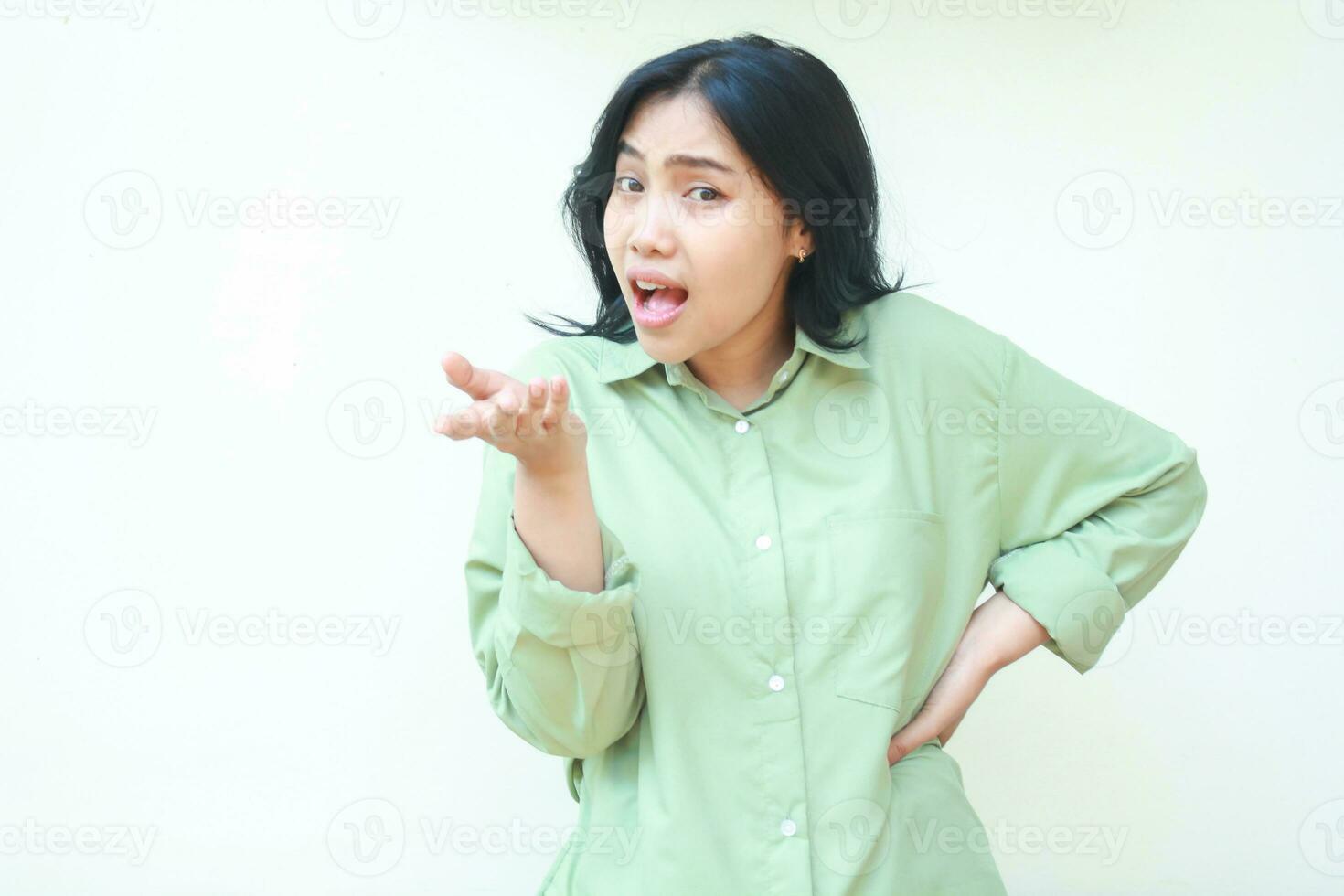 studio shot of angry asian woman standing over isolated white background with raising palms and hands on waist looking at camera show questioning gesture and mad expression photo
