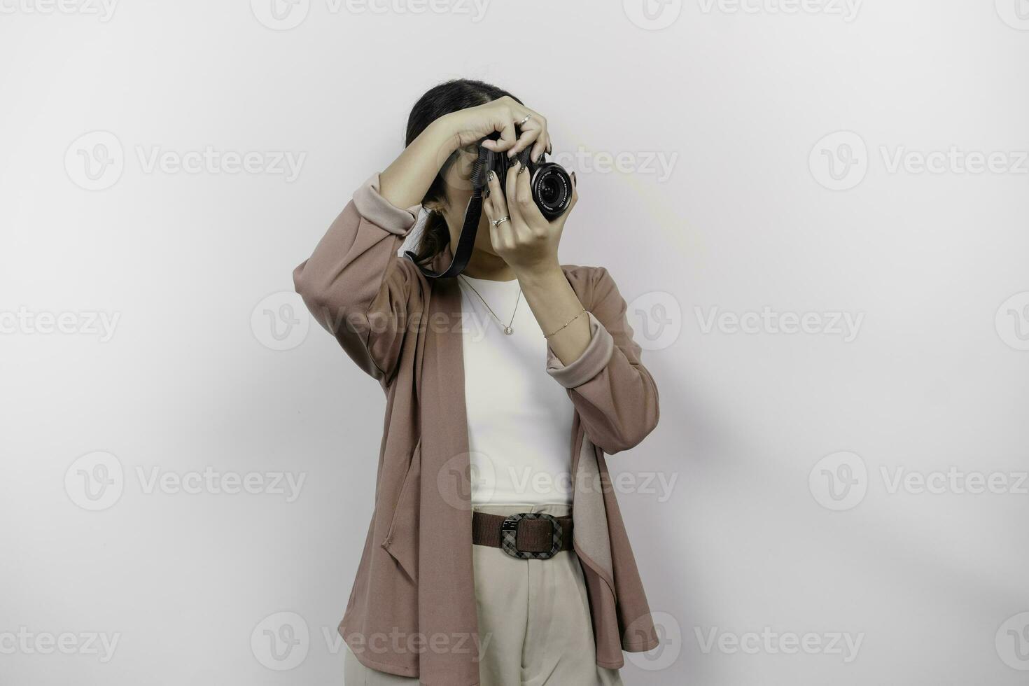 contento sonriente joven asiático mujer turista en pie con cámara tomando foto aislado en blanco estudio antecedentes