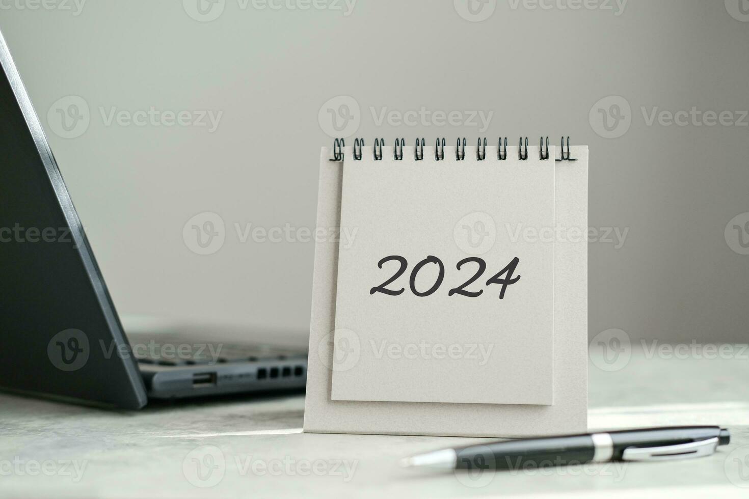 Calendar 2024 and laptop on office desk photo