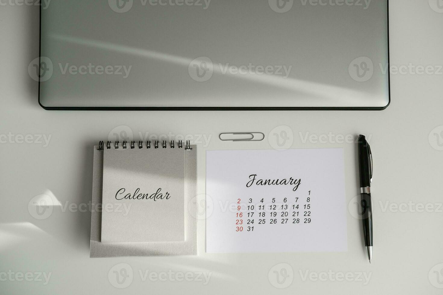 Top view of workplace with january calendar and laptop photo