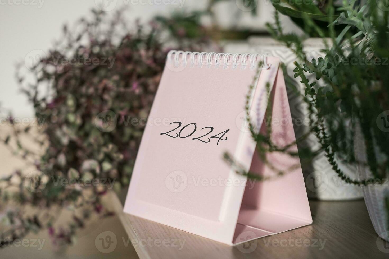 Desk calendar 2024 on a shelf among house plants photo