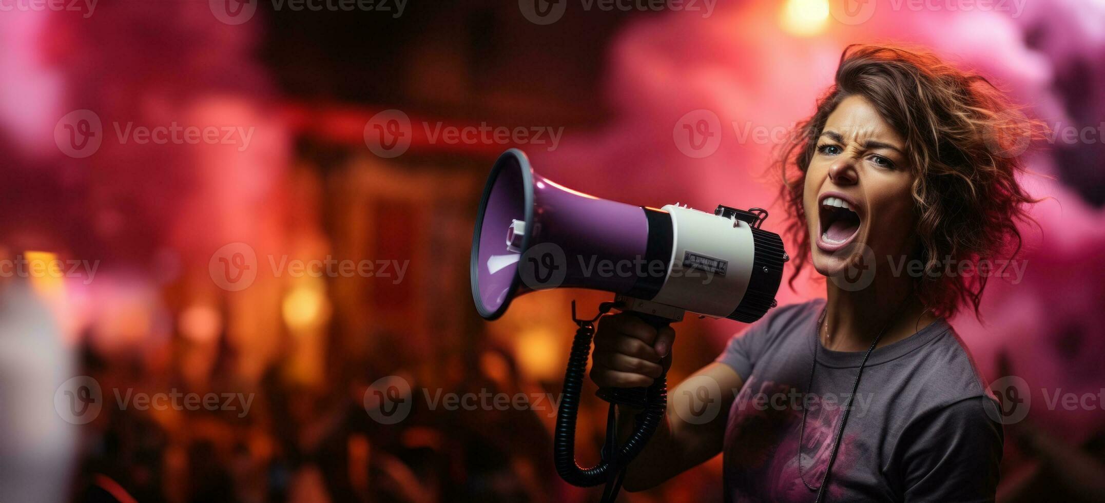Activist shouts angrily into a megaphone at rally, banner with copy space, defending women's rights photo