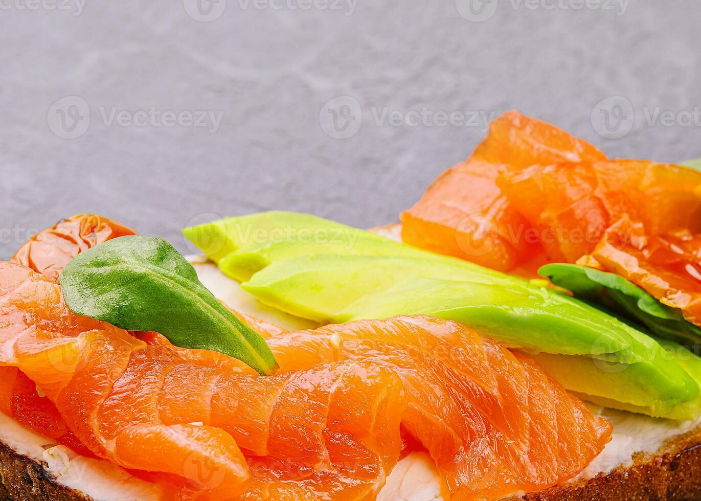 Homemade toast sandwich with salmon, avocado and basil photo