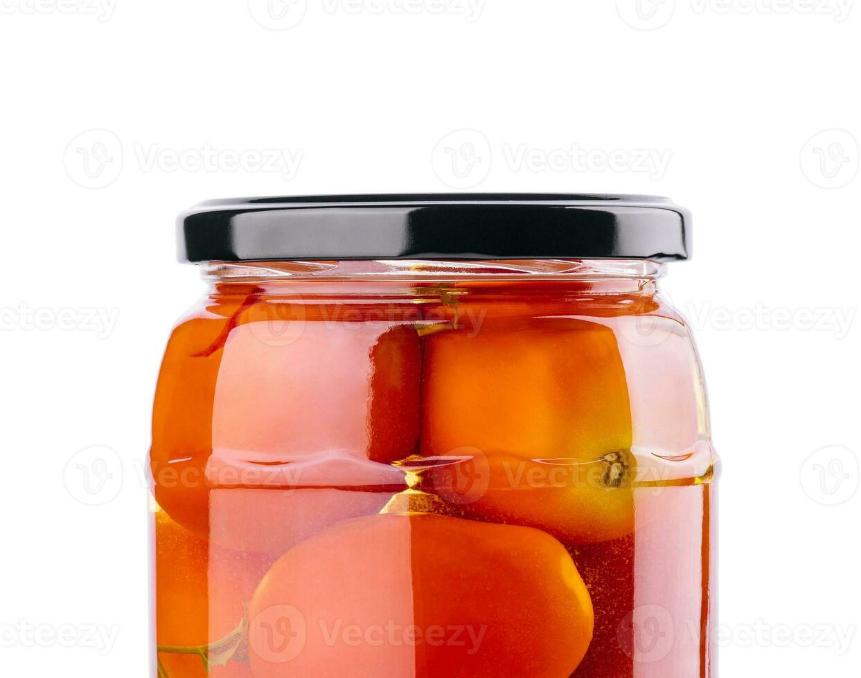 Pickled tomatoes in glass jar on white background photo