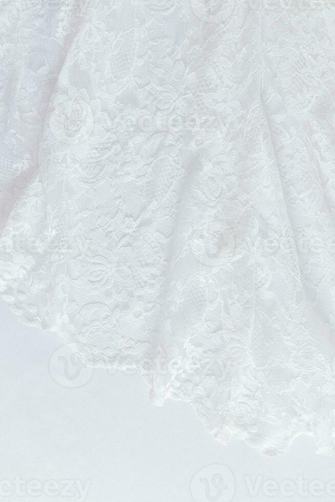 Chic white wedding background. Soft pleats of lace vintage fabric. Floral ornament. Vertical view. A copy of the space. Design mockup. photo