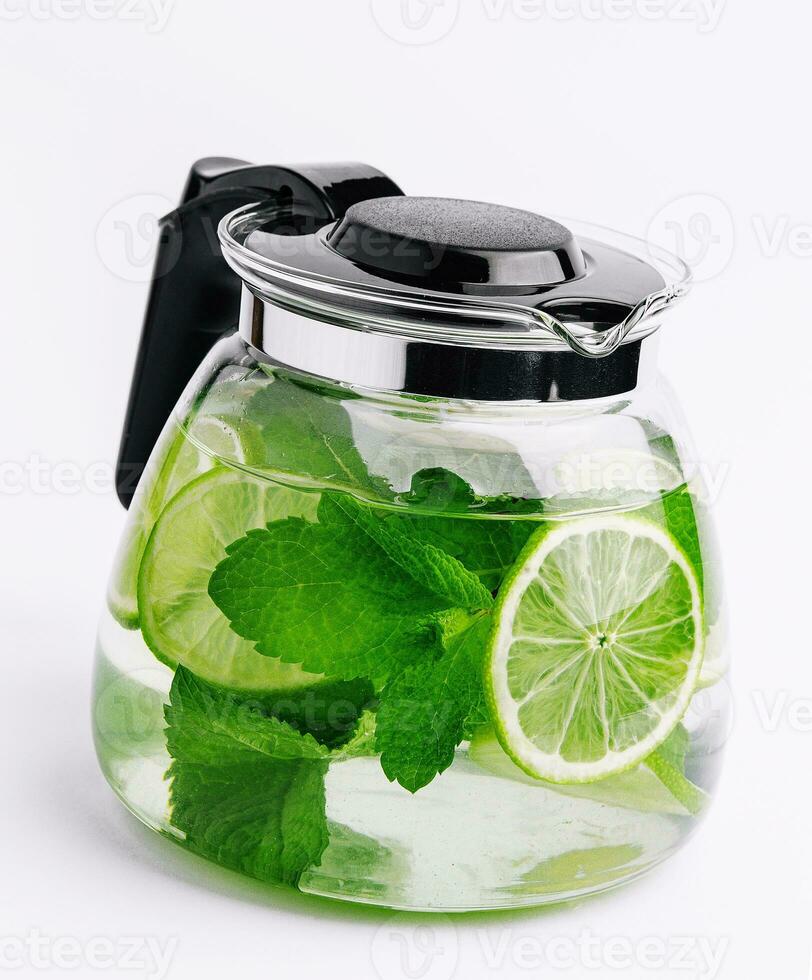 Fruit water with lime and mint in glass pitcher photo