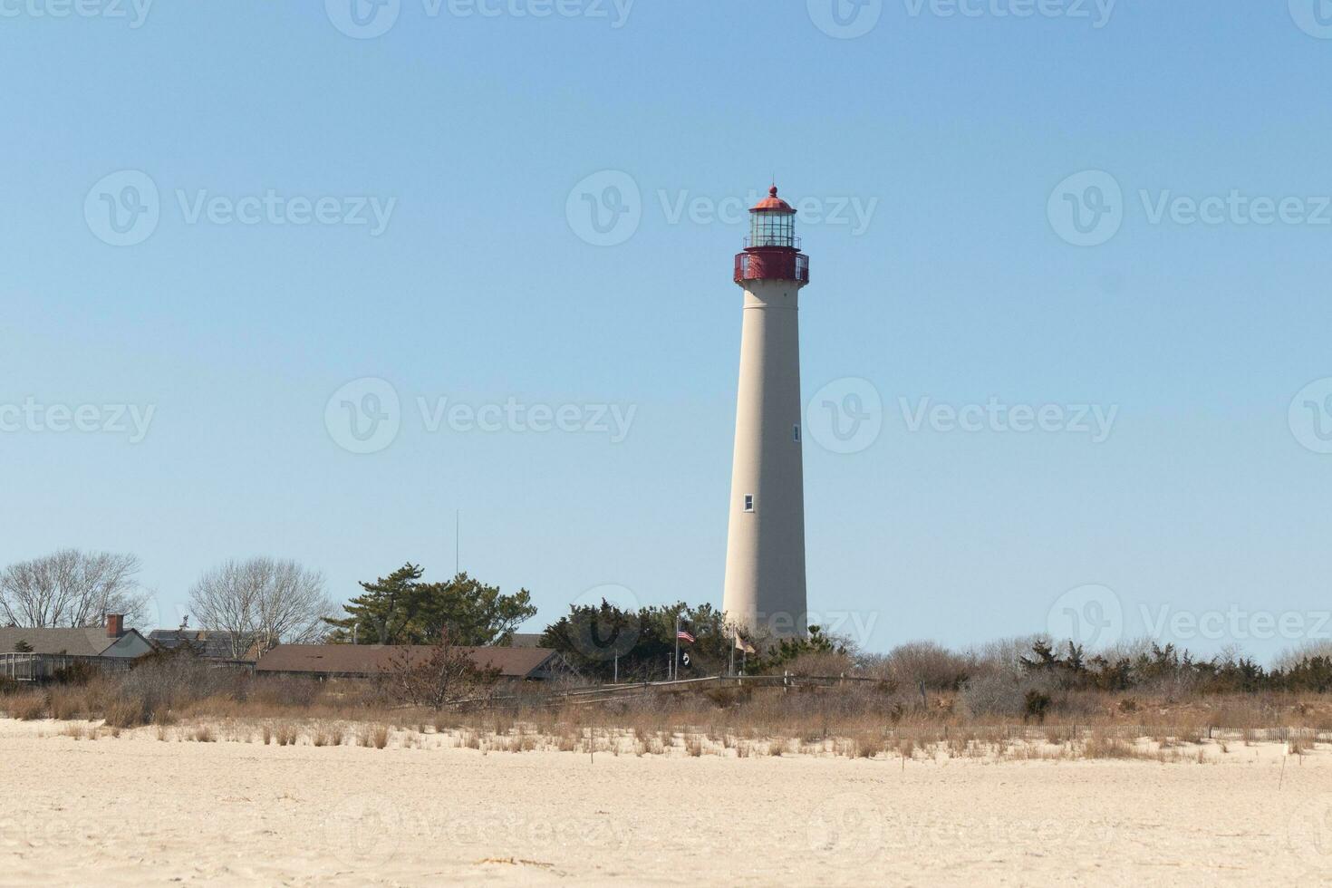 esta es capa mayo punto faro visto desde el playa. el alto blanco estructura con rojo metal sirve como un Faro de seguridad. foto