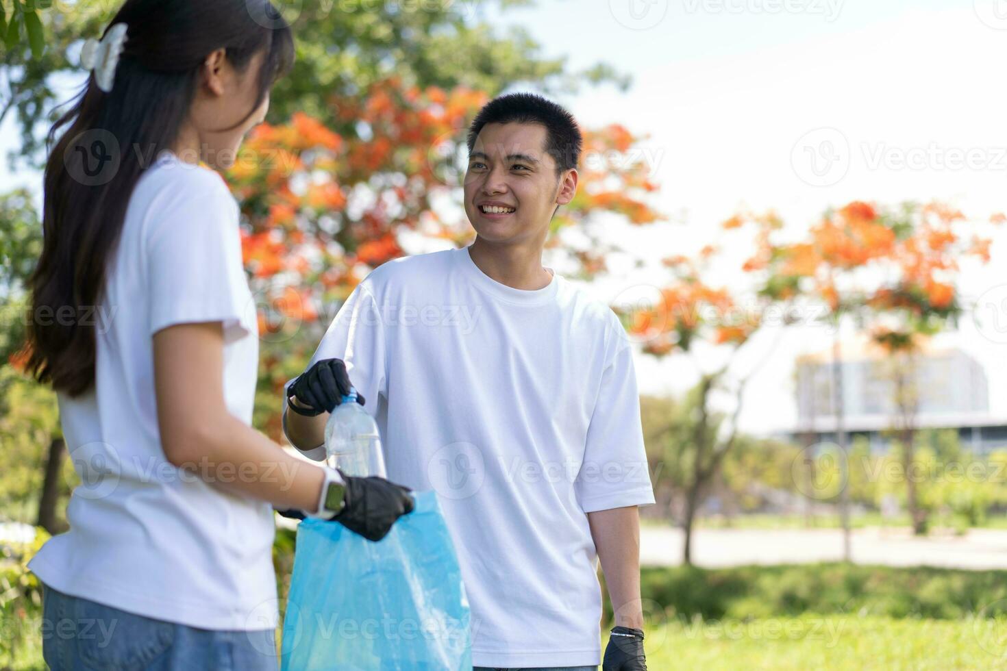 Happy young Asian students diverse volunteers with garbage bags cleaning area in the park, The concept of environmental conservation on world environment day, recycling, charity for sustainability. photo