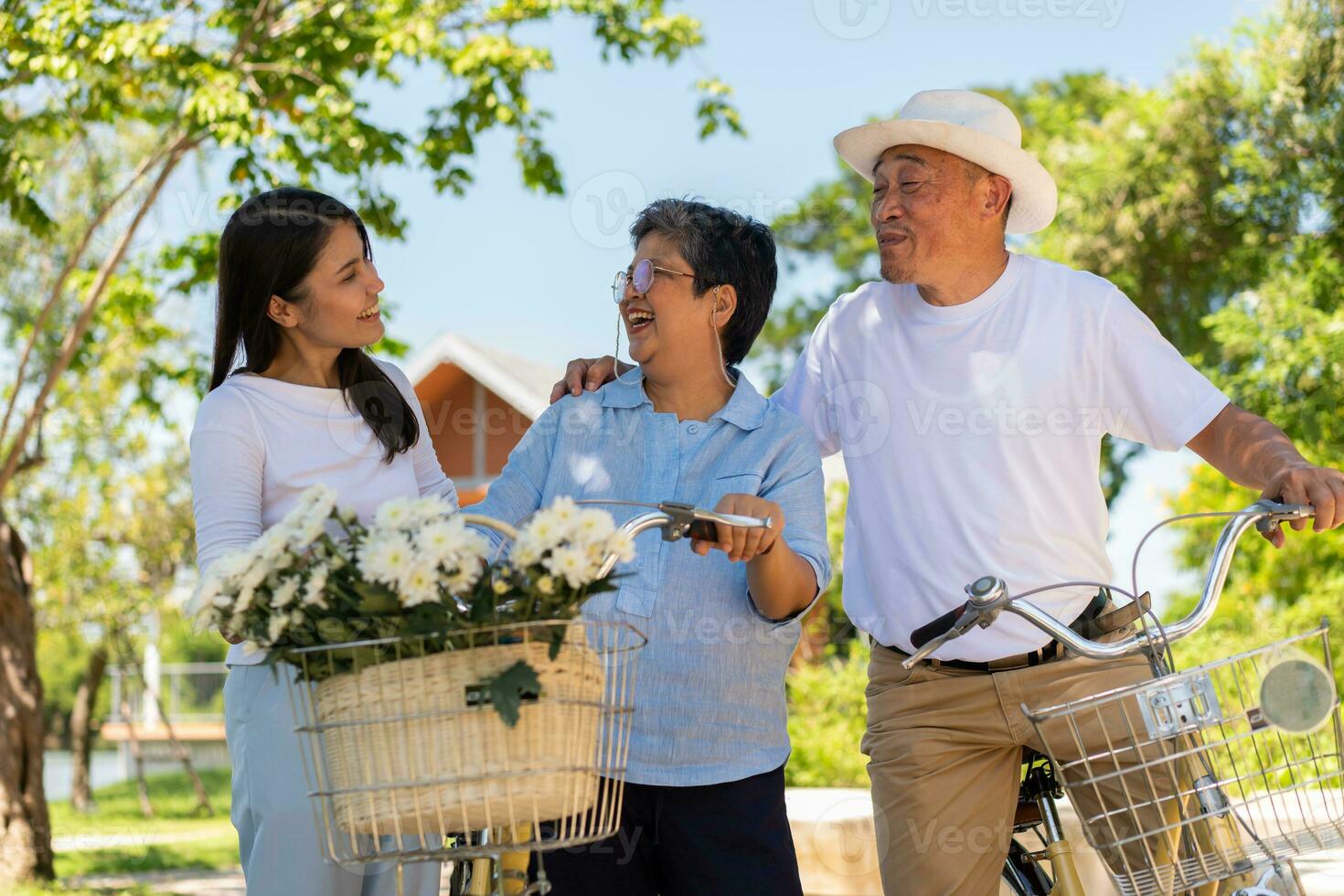 Happy and healthy Asian family standing beside a bicycle after workout together.  friendship lifestyle, Enjoyment of active seniors, outdoor activity after retirement, health care insurance concept. photo