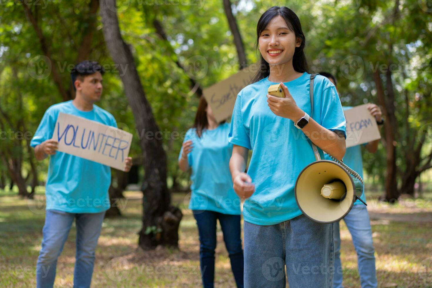 Happy young Asian students diverse volunteers hold a campaign sign for cleaning in the park, The concept of environmental conservation on world environment day, recycling, charity for sustainability. photo