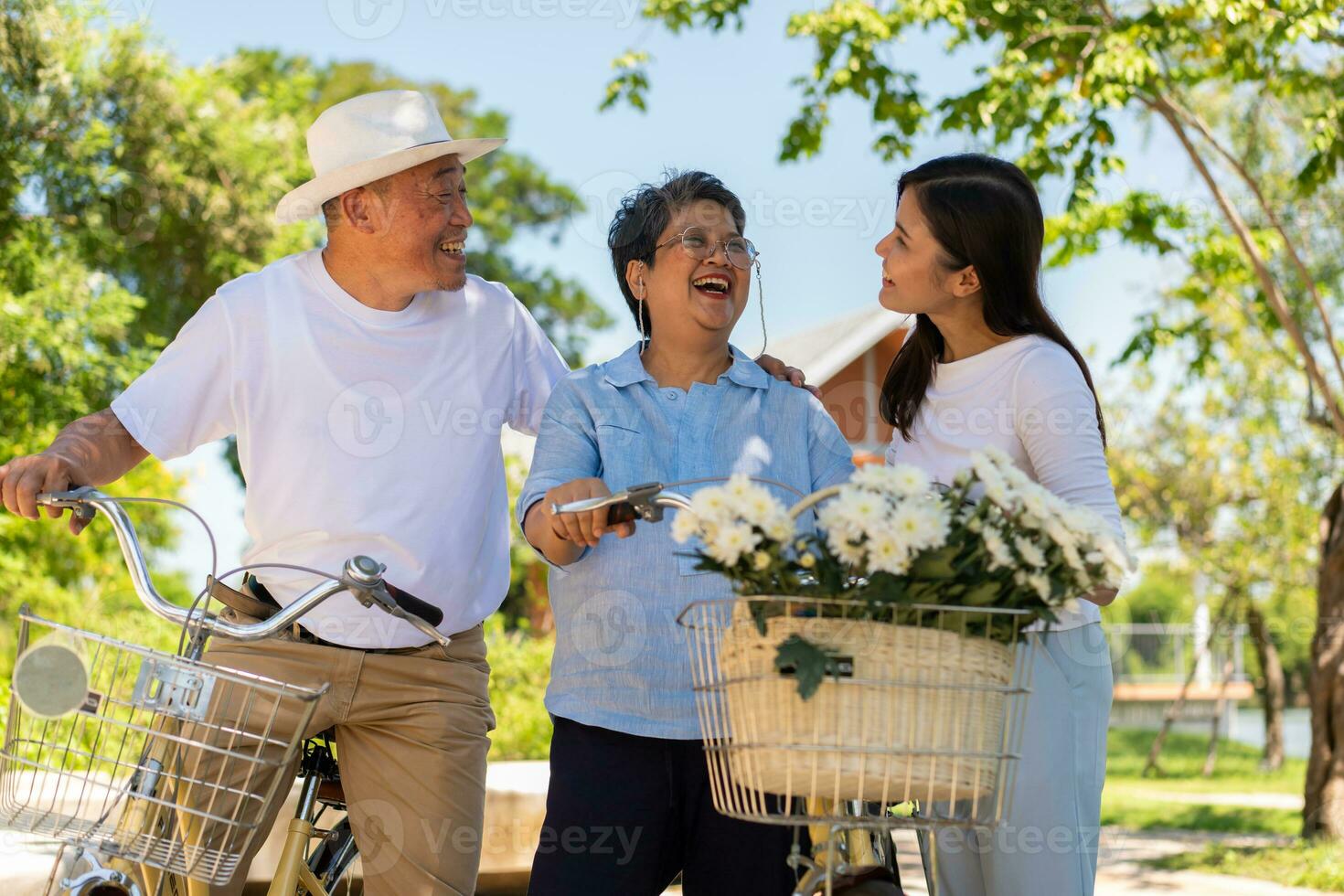 Happy and healthy Asian family standing beside a bicycle after workout together.  friendship lifestyle, Enjoyment of active seniors, outdoor activity after retirement, health care insurance concept. photo