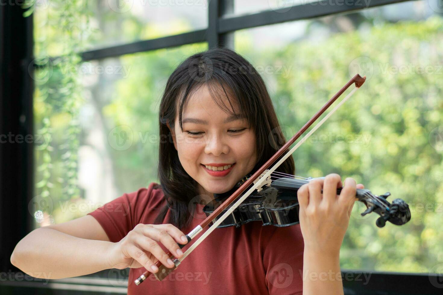 An attractive woman learning musician plays the violin at home.  Composer creating songs with string instruments. Dreamy violinist fingers pressing strings on violin photo