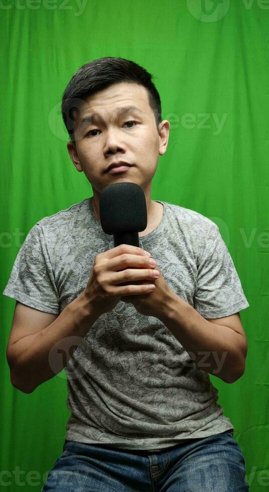 A Confident Man Holding a Microphone with Authority and Charisma photo