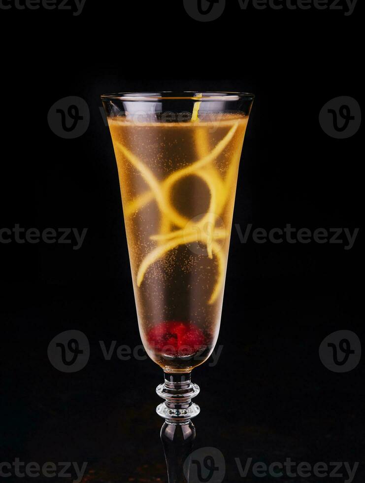 Elegant glass of yellow champagne with raspberry photo